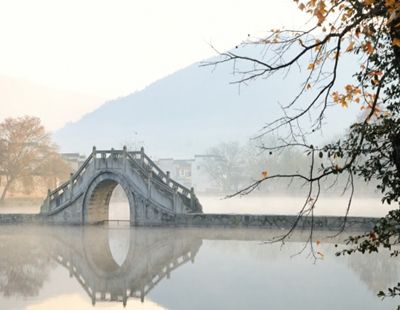 Traditional stone bridge over misty river