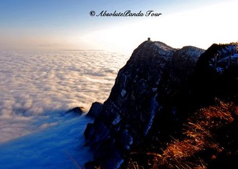 Mountain peak above clouds at sunrise