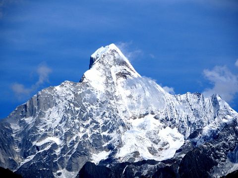 Sharp snow-covered mountain under blue sky
